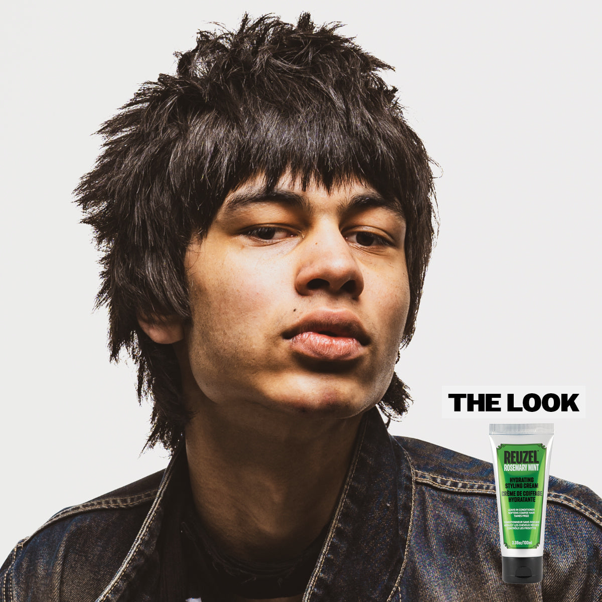 Person with styled hair with Reuzel Hydrating Styling Cream and a tube of hair product labeled 'The Look' on a gray background