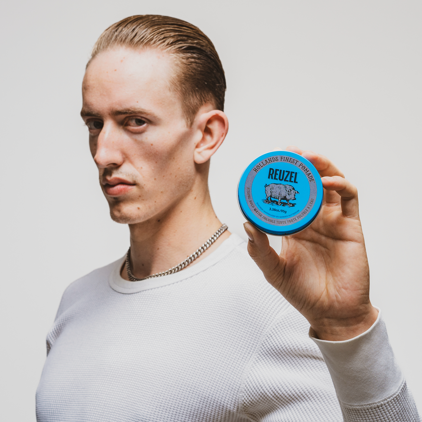 Reuzel Deutschland Road Trip To Go Blue Pomade in a jar, showcasing the vibrant blue-colored styling pomade for hair.