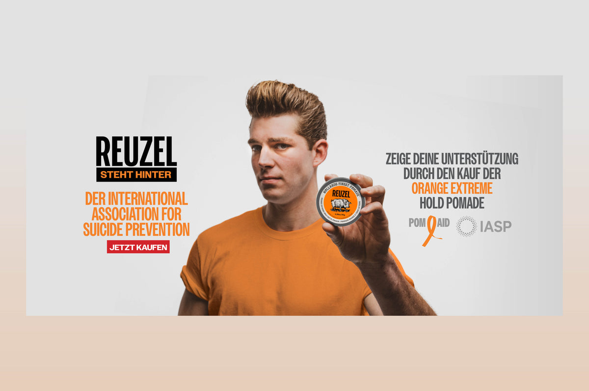 A man in an orange t-shirt holds up a tin of Reuzel Pom Aid Orange Extreme Hold Pomade against a light gray background with German promotional text.