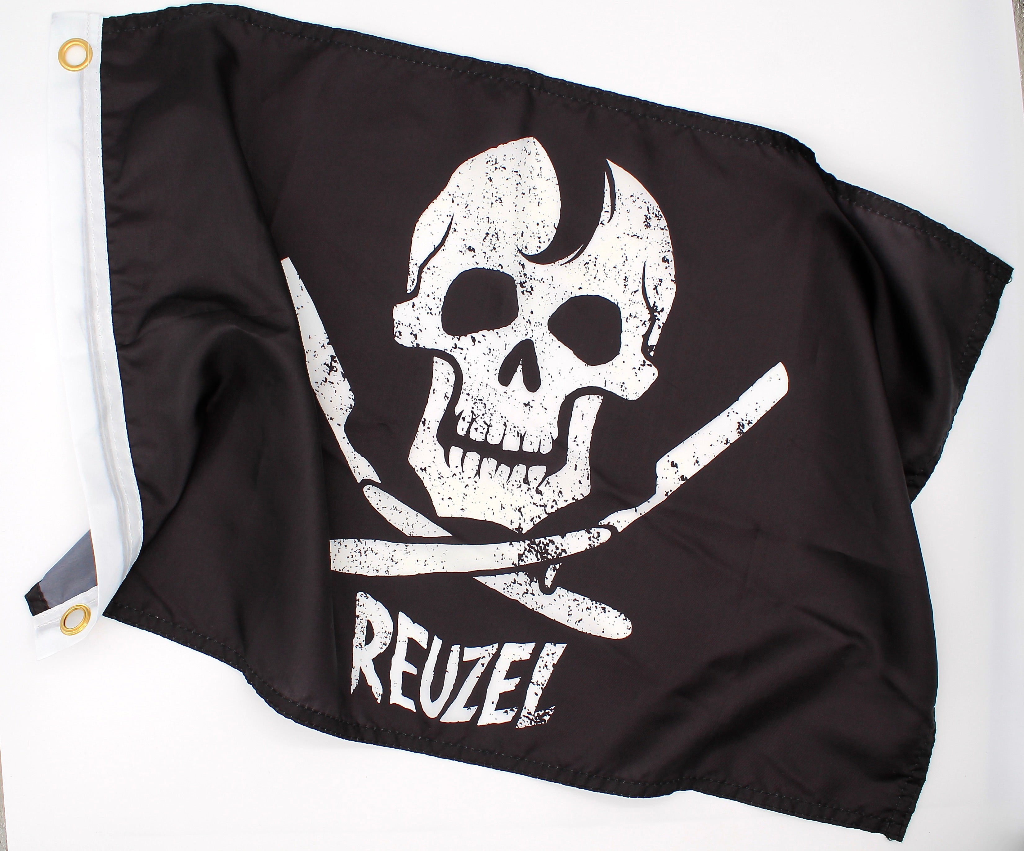 Black pirate flag with a white skull and open razors design and 'REUZEL' branding on a white background.