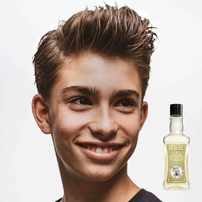 Person with styled hair next to a bottle of REUZEL 3 in 1 Shampoo on a white background