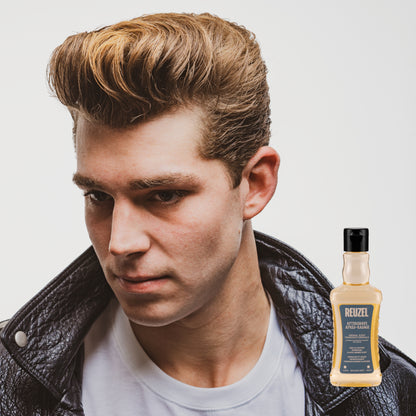Man with styled hair wearing a leather jacket, with a bottle of Reuzel Aftershave