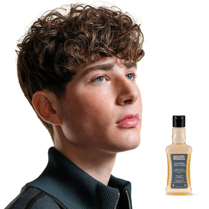 Man with styled hair next to a bottle of Reuzel Aftershave on a white background