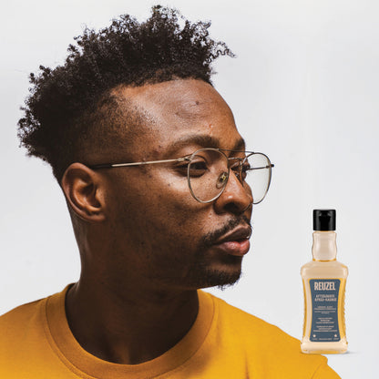Man wearing glasses with a bottle of REUZEL Aftershave in the corner.