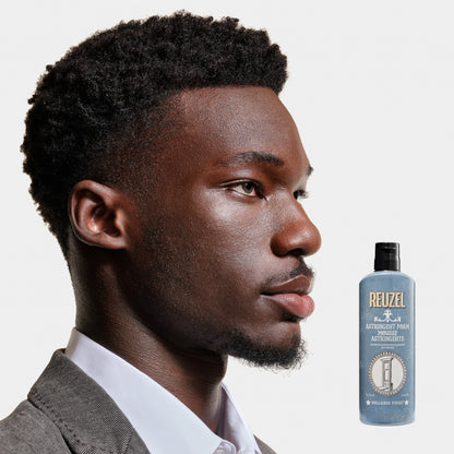 Man with styled hair next to a bottle of Reuzel Astringent Foam on a white background