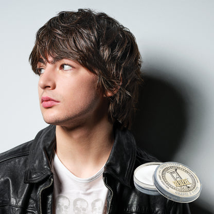 Person wearing a black leather jacket and Reuzel Shave Cream against a gray background